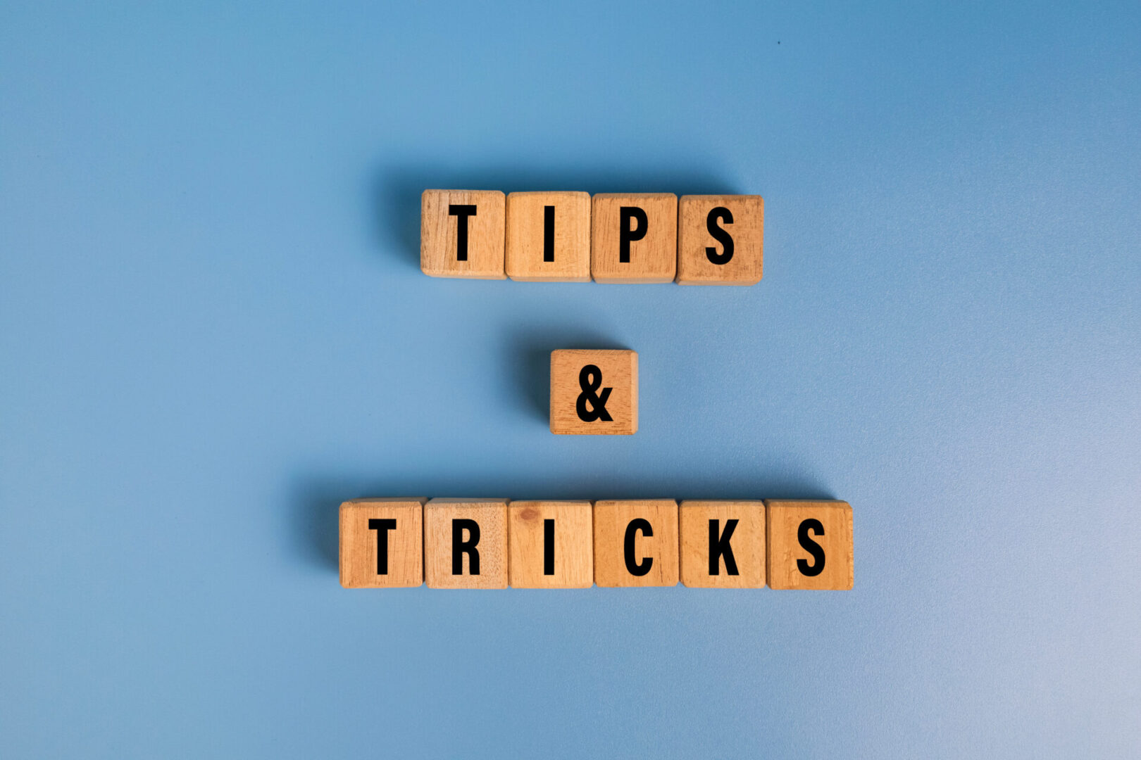 tips and tricks words on wooden blocks isolated on blue background tips and tricks words on wooden blocks isolated on blue background